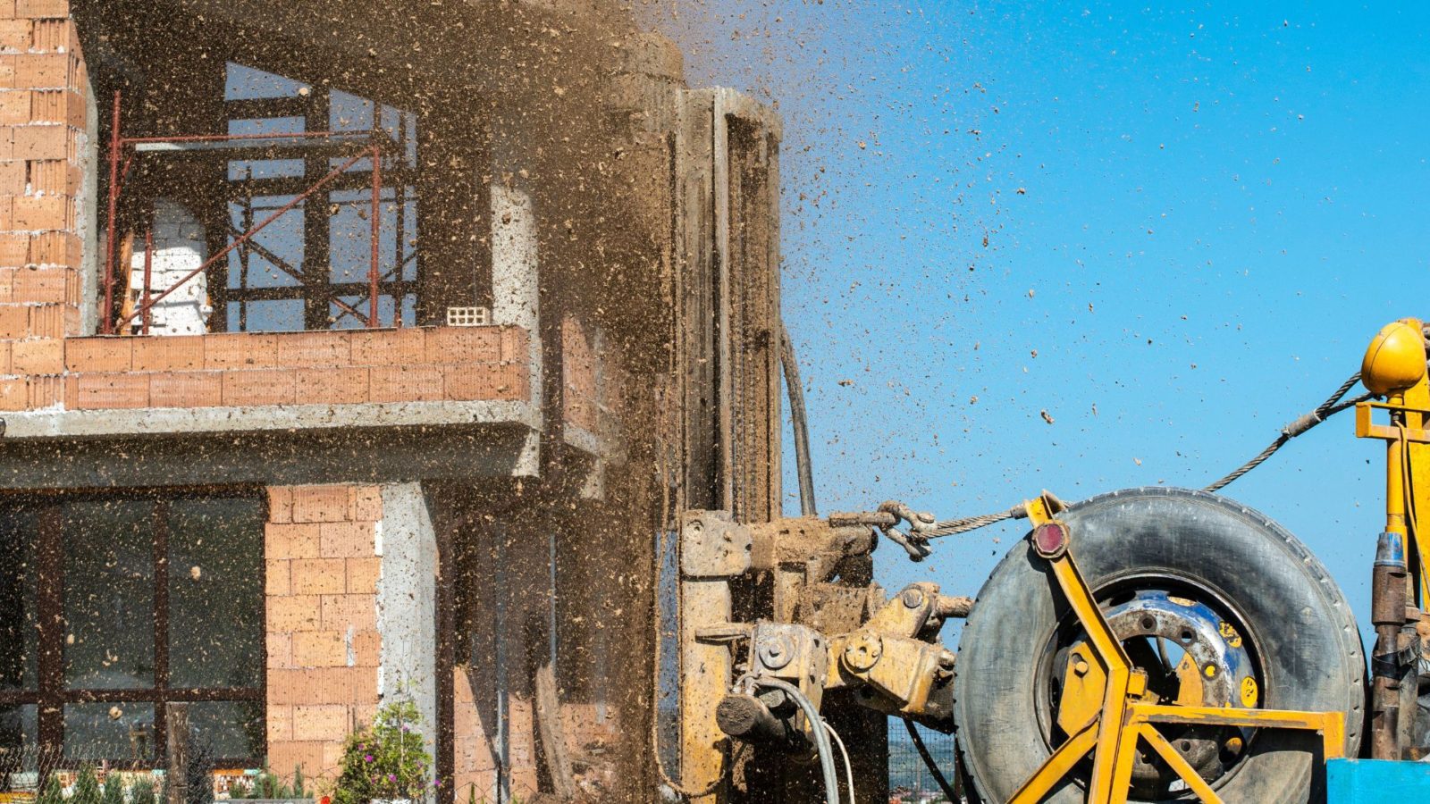 Maison en cours de construction sur un chantier avec des travaux de fondation visibles